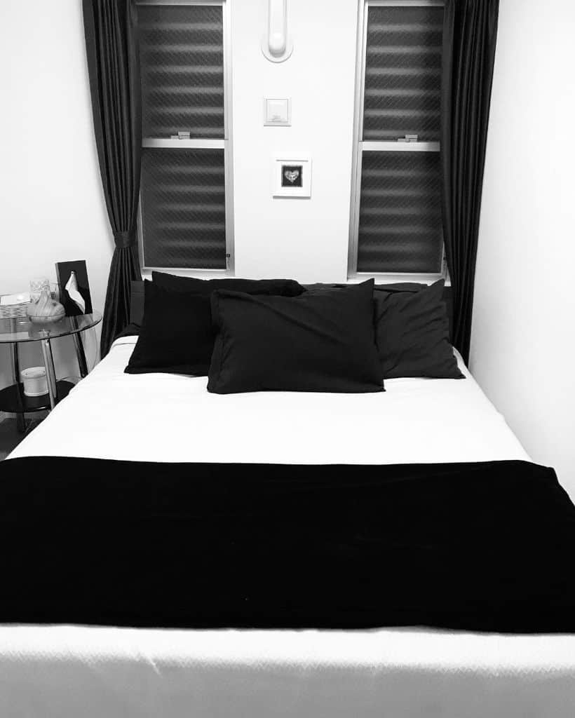 monochrome bedroom with glass side table 