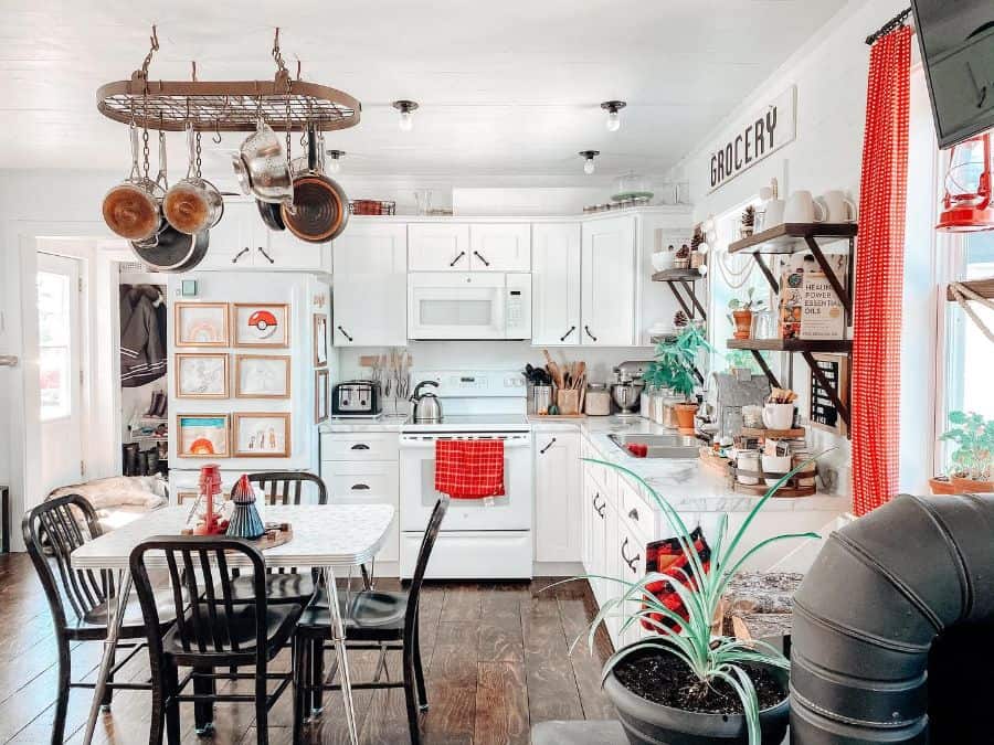 country style kitchen white cabinets dining table four black chairs hardwood floors 