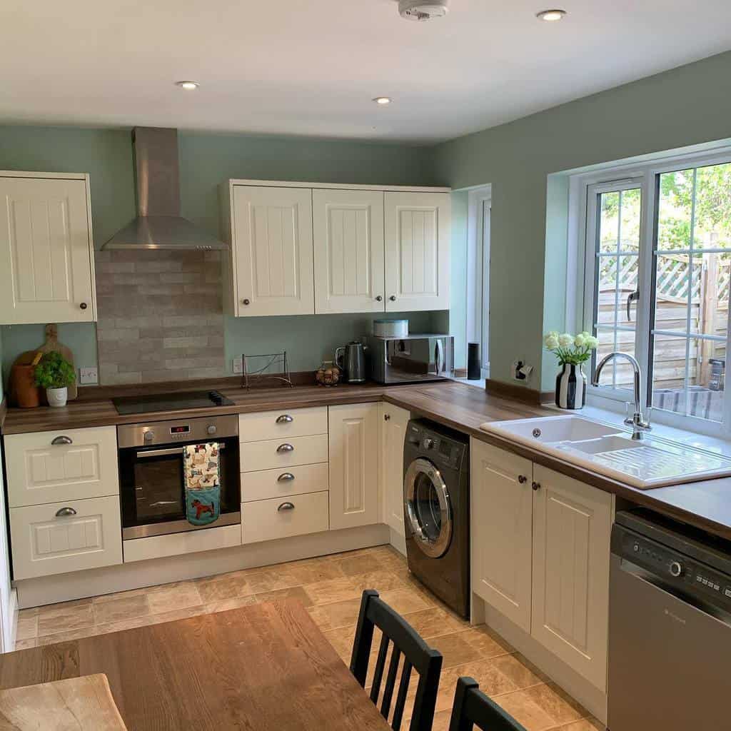 white cabinet corner kitchen green walls wood countertops 