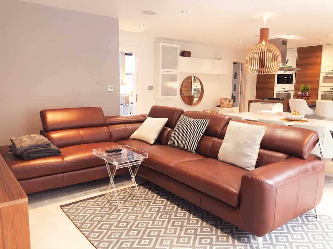 open plan kitchen living room brown couch gray accent wall