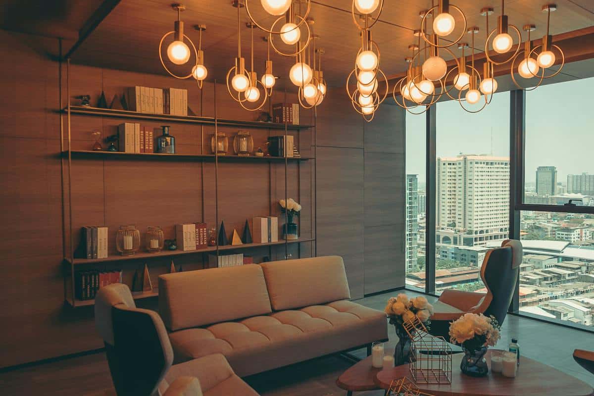 luxury apartment living room gray couch hanging bookshelf unique chandelier