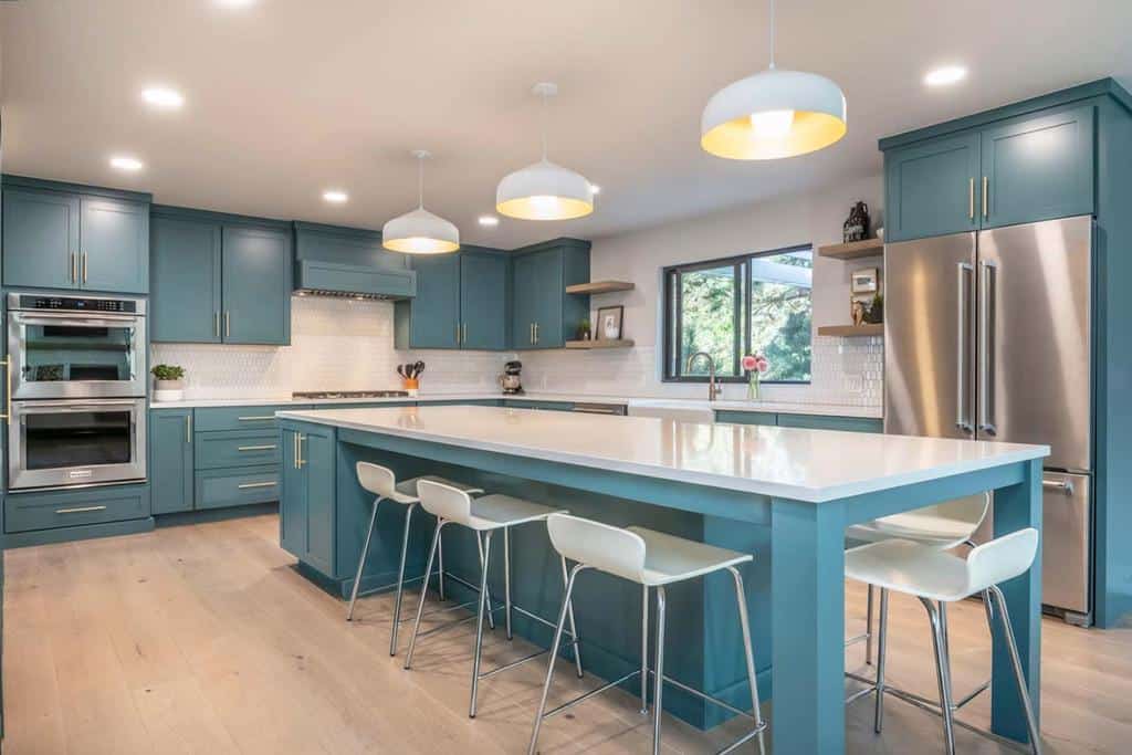 large spacious blue cabinet modern kitchen white countertop and chairs 