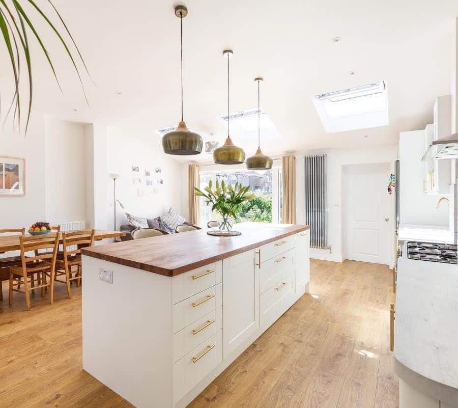 white cabinet kitchen with gold accents and wood countertop 