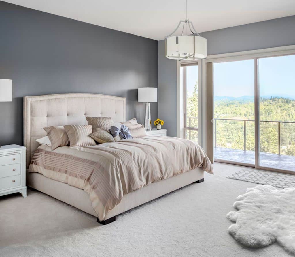 modest master bedroom white floor rug balcony forest view