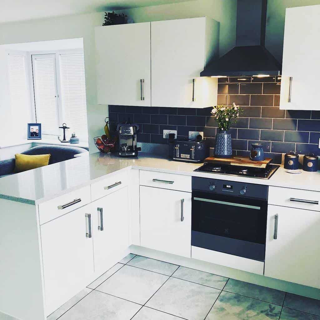 white corner cabinet kitchen black tile backsplash 