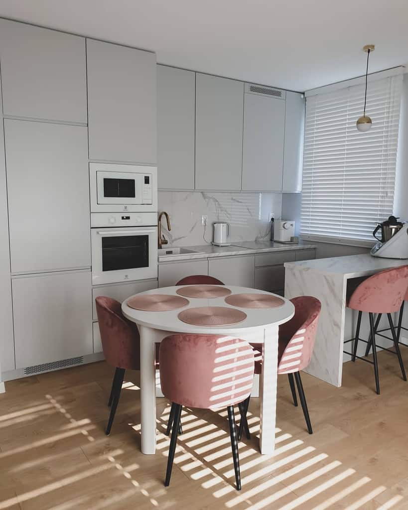 small gray kitchen white circular table four pink seats vinyl wood flooring 